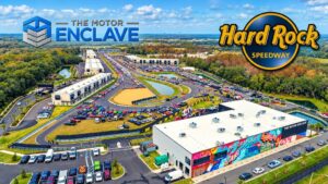A spectacular aerial view of The Motor Enclave in Tampa, Florida, showcases the 1.72-mile Hard Rock Speedway, hundreds of luxury private car garages, and a massive automotive event center.