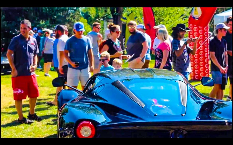 Car fans gazing at the newest Ferrari at the Automezzi car show in Anderson Park Colorado