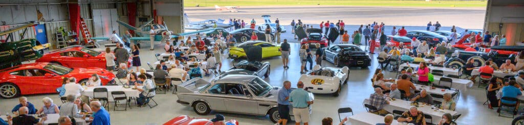 Car show in an airport hangar