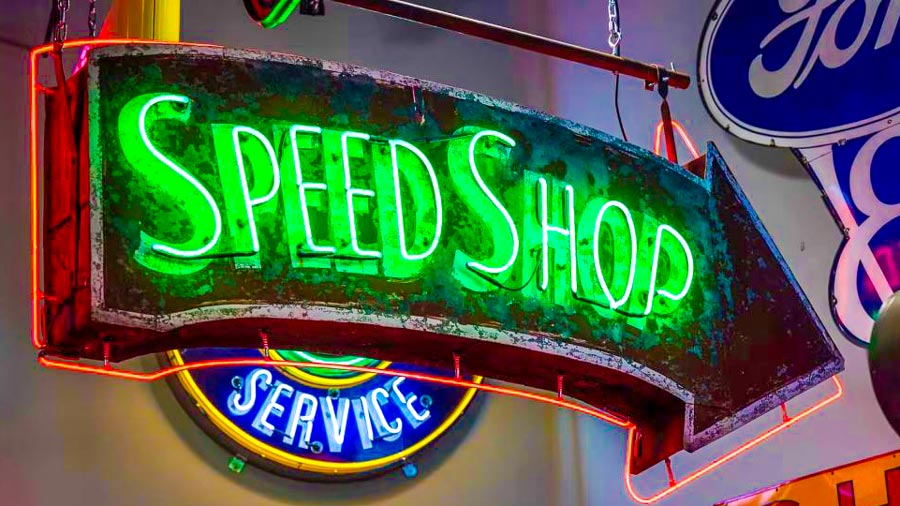 Here is a 1940s double-sided tin neon sign in its original cabinet, shining with great patina. The sign prominently features the famous Rocco and Cheater’s Speed Shop from Birmingham, Alabama