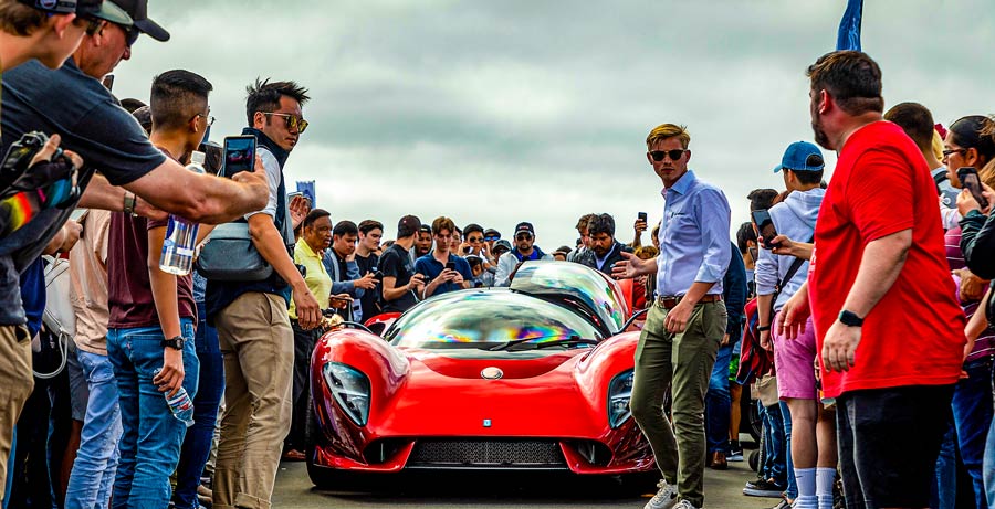 a supercar with people looking at the car