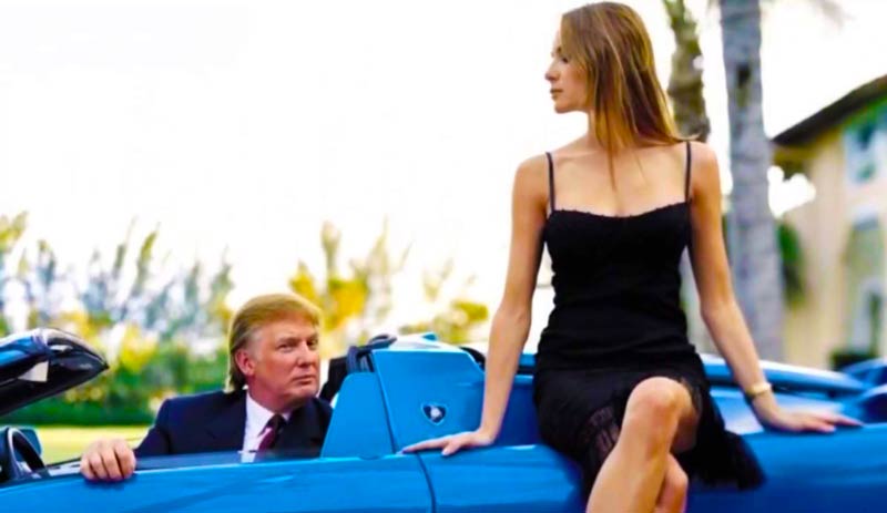 Donald Trump is a Lamborghini Diablo VT Roadster with a girl sitting on the car next to him. 