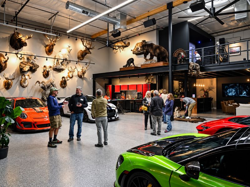 A custom two story Motor-Vault garage suite with people and multiple cars